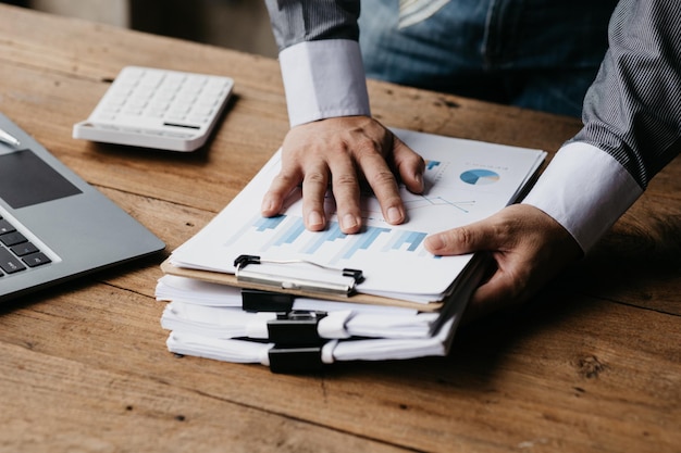 Businessman holding a pile of company financial documents he is\
checking company finances before attending a meeting with the\
finance department concept of corporate financial management