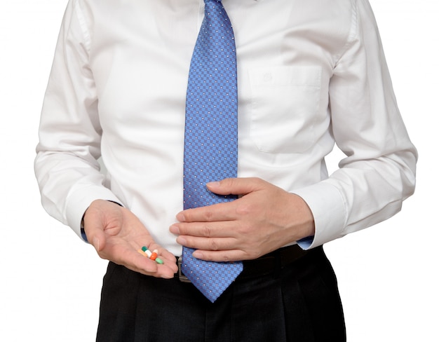 Businessman holding pill in hand.