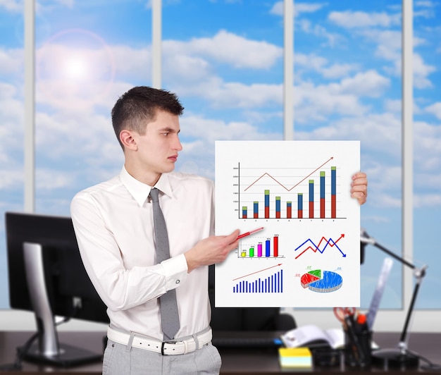 Businessman holding placard with charts