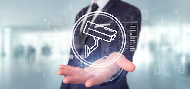 Businessman holding Security camera system icon and statistics data