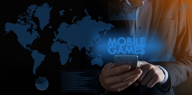 Uomo d'affari che tiene uno smartphone con iscrizione mobile game