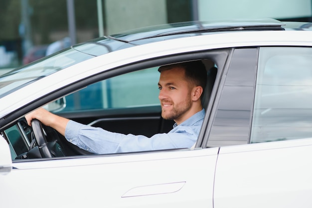 Businessman holding steering wheel while driving modern electric car on the street road Confident man driving expensive car Driver Turning Steering Wheel In Luxurious Auto On Trip