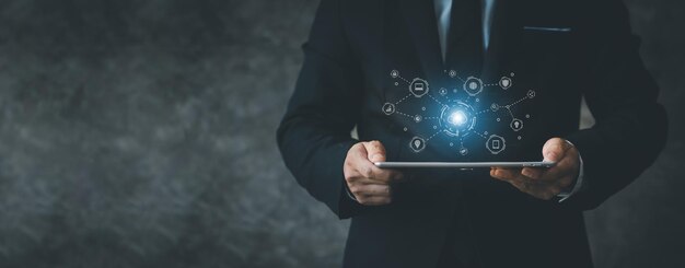 Businessman holding a tablet hologram icon online data network connection uploading data to cloud so that data can be transferred to other devices and can view data online at any time