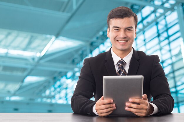 Businessman holding tablet and smile in office room.