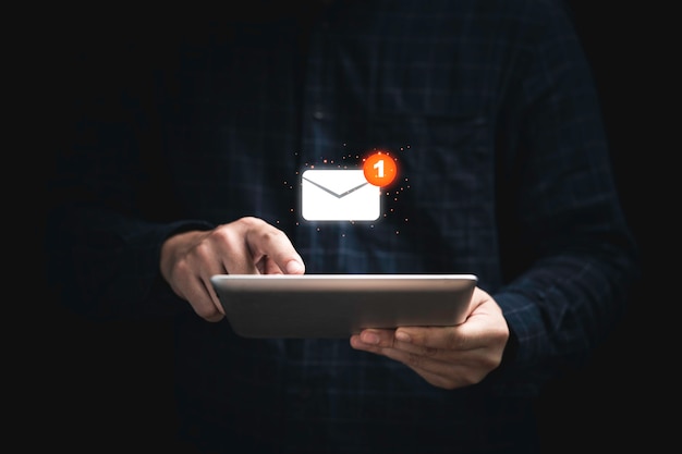 Uomo d'affari che tiene tablet e tocca con una newsletter bianca virtuale per posta elettronica o e-mail con concetto di avviso di notifica.