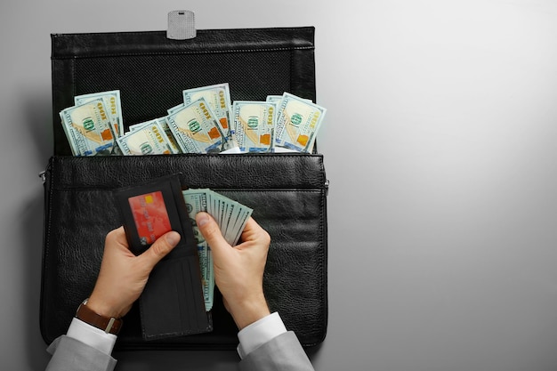 Businessman holding wallet and brief case with money