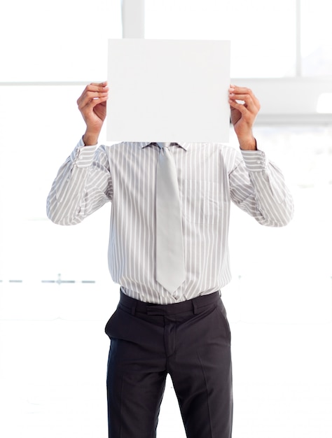 Photo businessman holding a white card covering his face