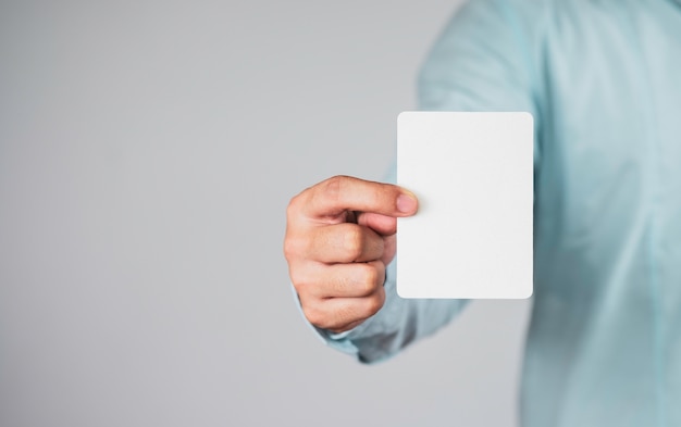 Businessman holding white paper, note or card