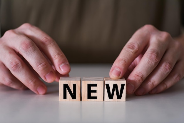 Photo businessman holding wooden cubes with new word