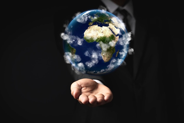 Businessman holding the world in the palm of hands concept for global business