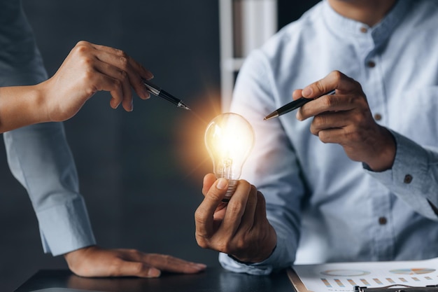 Businessman holds a glowing lamp Creative new idea Innovation brainstorming strategizing to make the business grow and be profitable Concept execution strategy planning and profit management