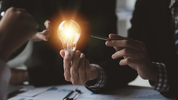 Businessman holds a glowing lamp Creative new idea Innovation brainstorming strategizing to make the business grow and be profitable Concept execution strategy planning and profit management