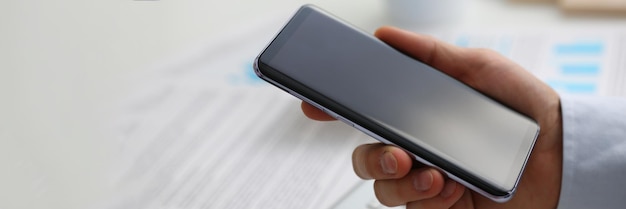 L'uomo d'affari tiene in mano il nuovo smartphone moderno