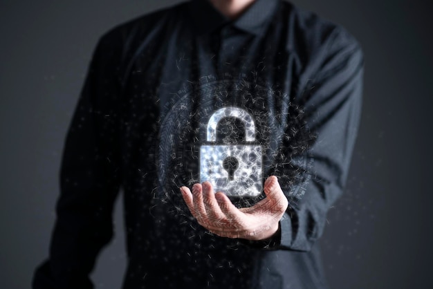 A businessman holds a lock icon hologram as the symbol of online data and information security