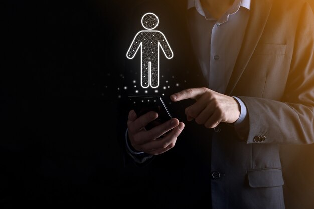 Businessman holds man person icon on dark tone background.HR Human ,people iconTechnology Process System Business with Recruitment, Hiring, Team Building. Organisation structure concept.