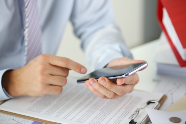 A businessman holds a new smartphone