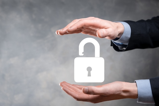 Businessman holds an open padlock icon on his palm.unlocking a virtual lock. Business concept and technology metaphor for cyber attack, computer crime, information security and data encryption.