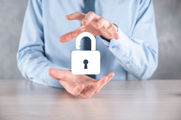 Businessman holds an open padlock icon on his palm.unlocking a
virtual lock. business concept and technology metaphor for cyber
attack, computer crime, information security and data
encryption.