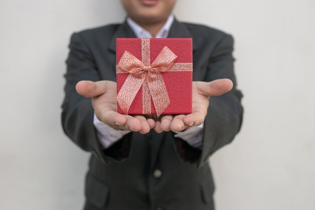 Businessman holds out the gift box