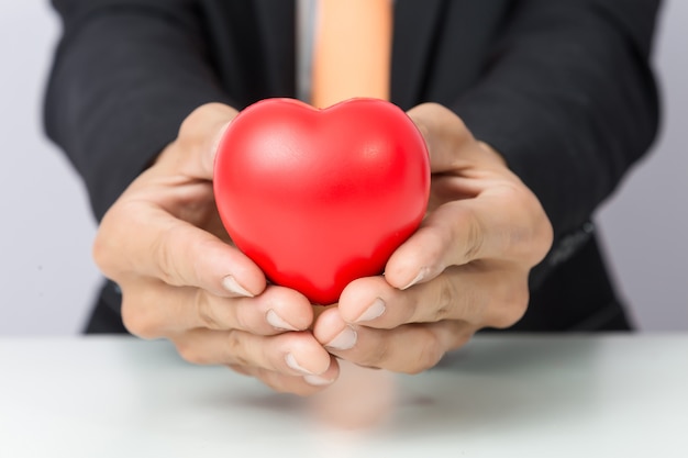 Businessman holds out the red heart