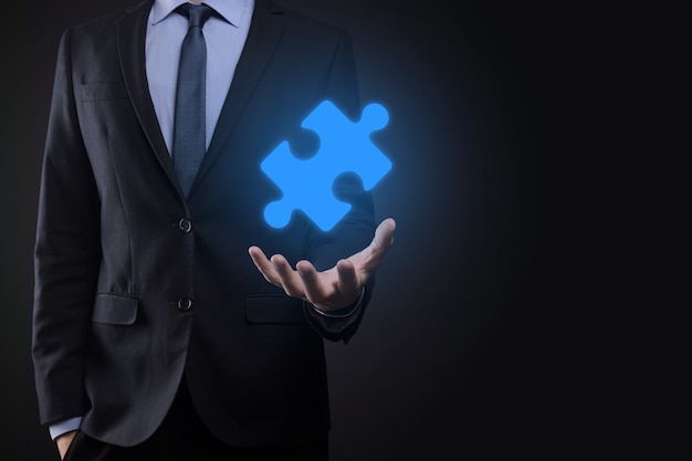 Businessman holds a piece of puzzle jigsaw in his hands