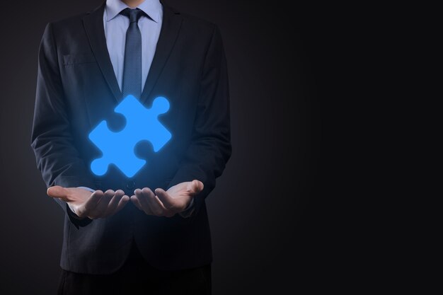 Businessman holds a piece of puzzle jigsaw in his hands