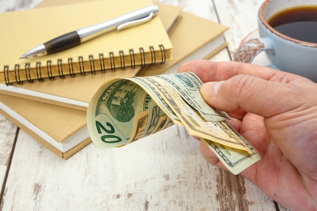 A businessman holds several dollar bills in his hand. Financial concept.