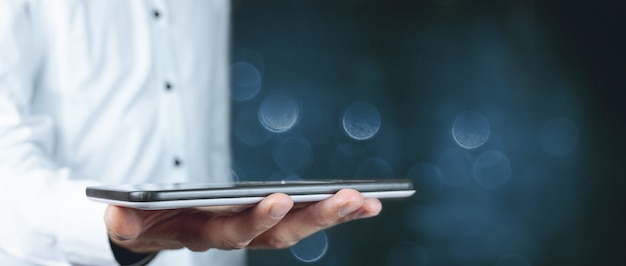 Businessman holds tablet in hand