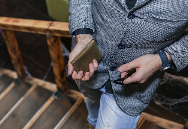 A businessman holds a wallet in his hands