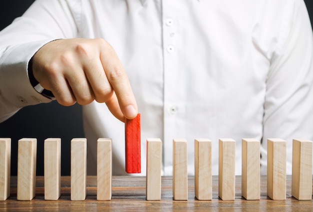 Businessman holds a wooden block in his hands. 