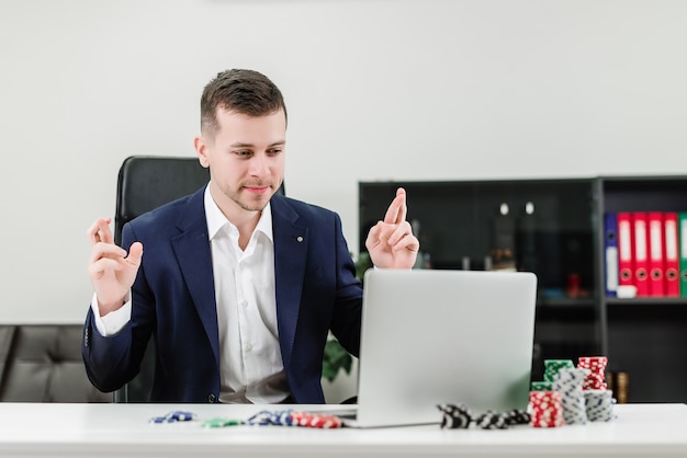 Businessman hoping to win in online casino while playing poker in the office