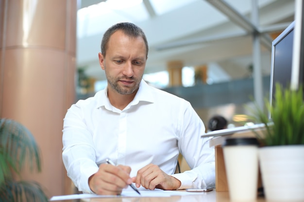 Businessman is deeply reviewing a financial report for a return on investment or investment risk analysis.