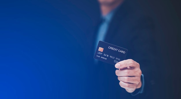 Businessman is holding credit card and using mobile phone. Online shopping concept,banking and online shopping at the home.Close up.