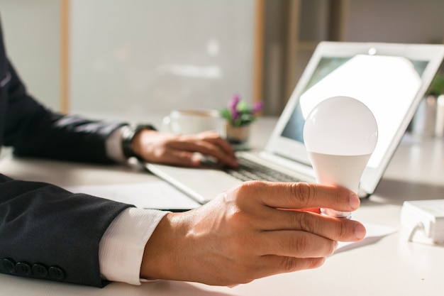 Businessman is holding light bulb as a creative model.