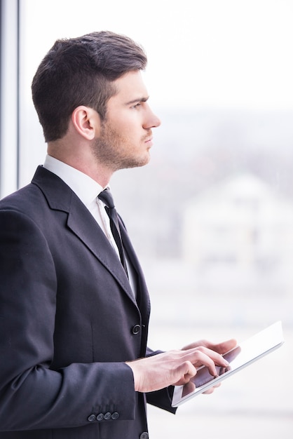 Businessman is holding a tablet in the office.