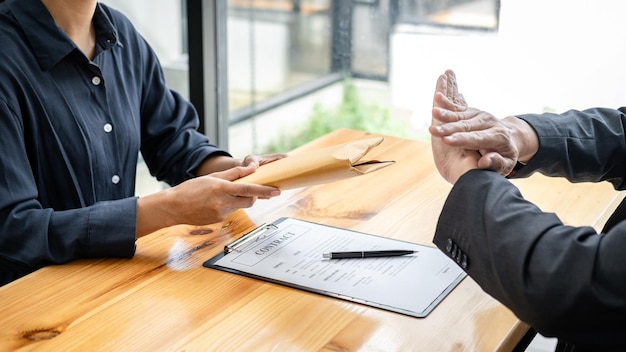 Photo businessman is refuses don't receive to accept banknote money and terms of contract from corruption bribe employer in signing agreement deal