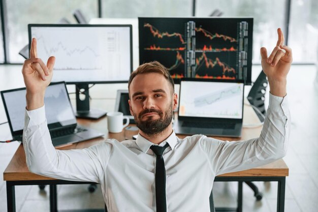 Photo businessman is sitting by computer and working in the office