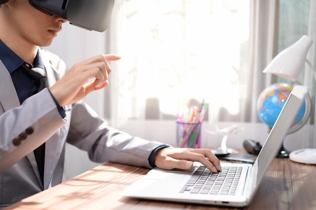 Businessman is using VR glasses to work. Virtual world.