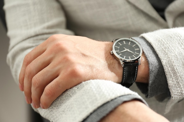Businessman in jacket with luxury wrist watch closeup