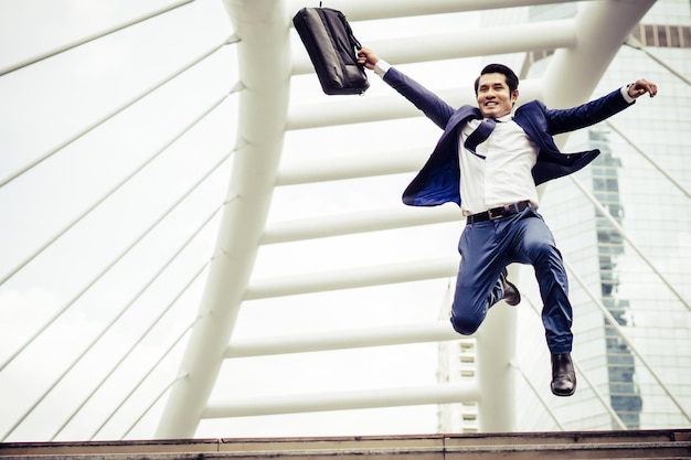 Photo businessman jumping on bridge in city