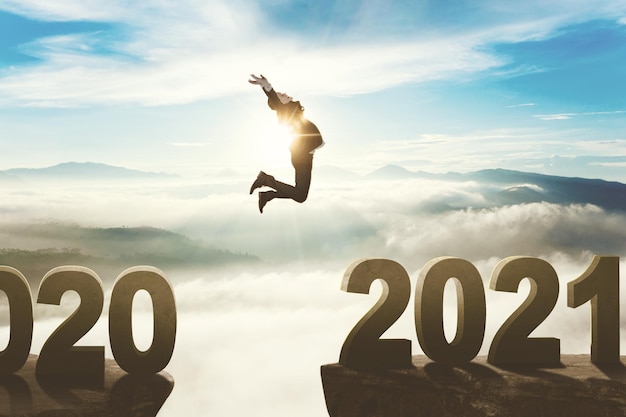 Businessman jumping through the gap to number 2021