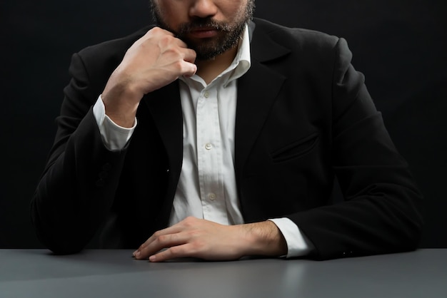 Businessman or lawyer wearing formal black suit sitting at table equility