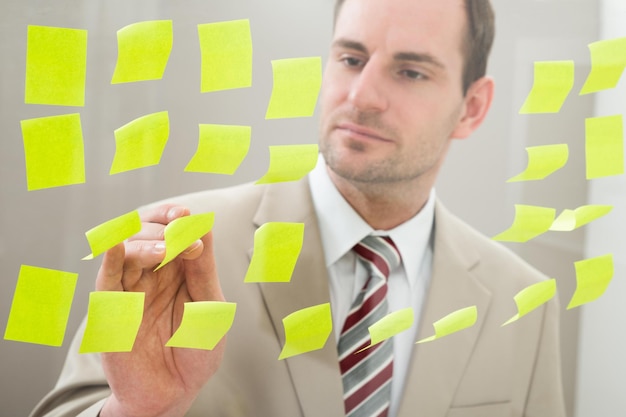 Businessman looking at adhesive notes