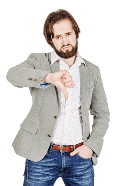 Businessman looking at camera and showing his thumb down while standing against white background