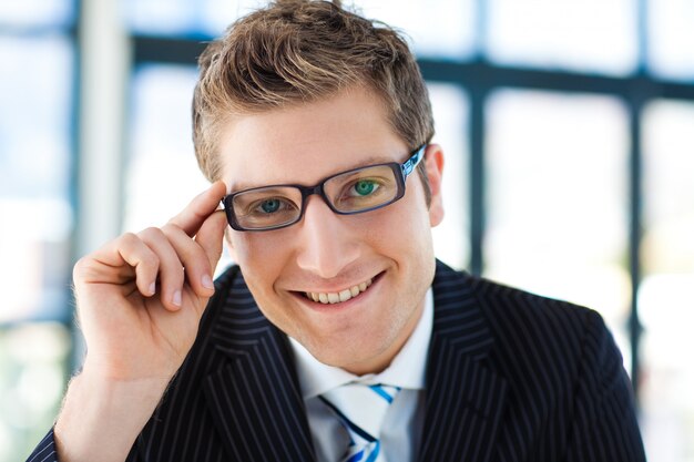 Foto uomo d'affari che guarda alla telecamera con gli occhiali