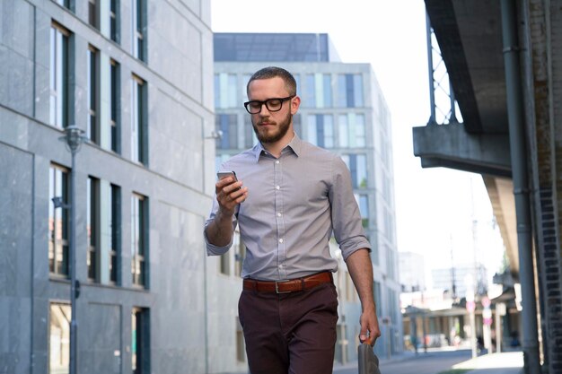 Businessman looking at cell phone in the city