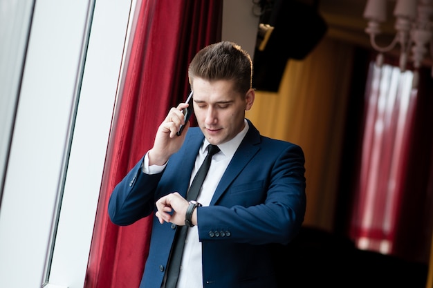 Businessman looking at clock and talking on the phone