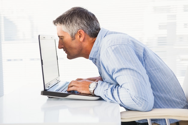 Photo businessman looking closely at the laptop