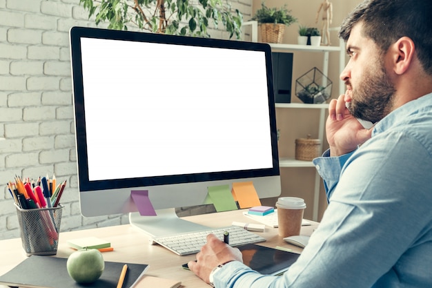 Businessman looking at computer monitor during working day in office