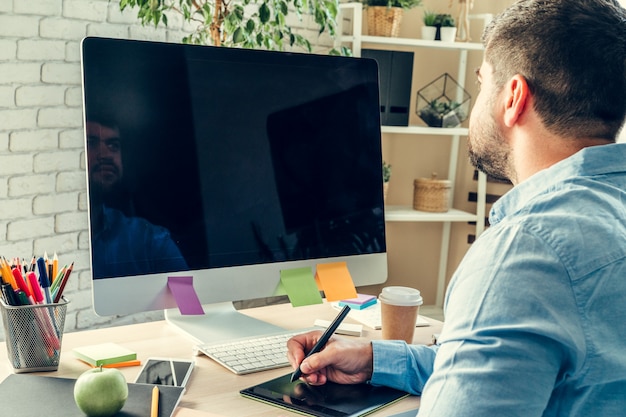 Businessman looking at computer monitor during working day in office